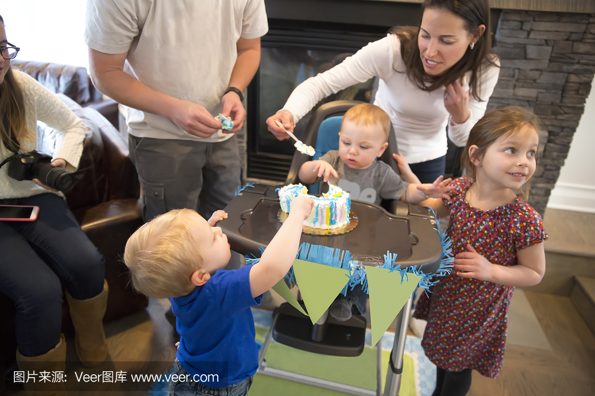 家庭庆祝一岁的男孩的生日蛋糕