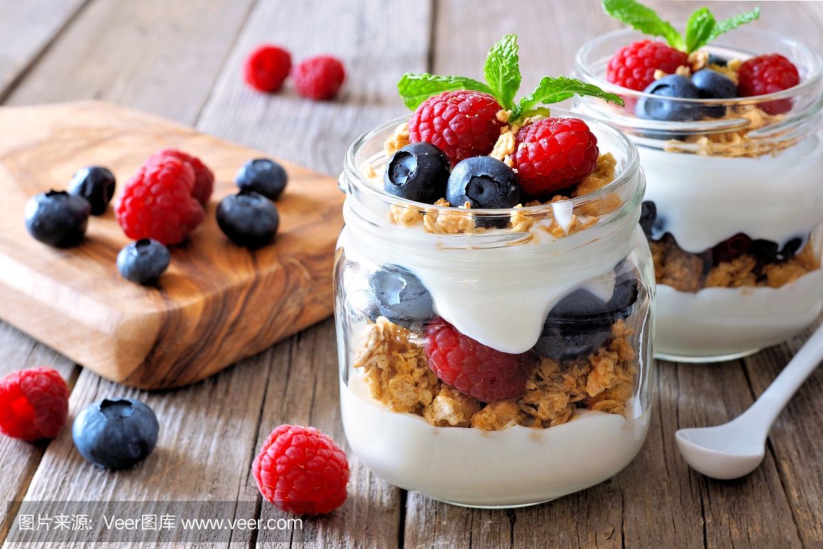 蓝莓,覆盆子在梅森罐头,静物在木头上