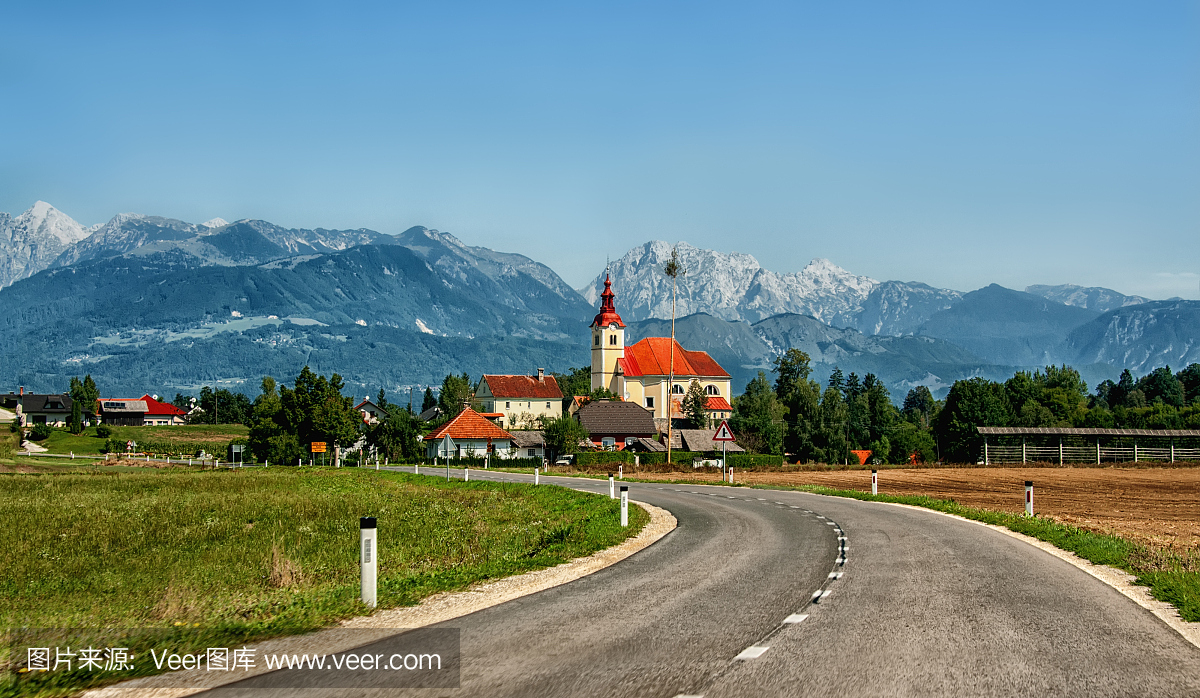 道路通往斯洛文尼亚山脉的背景下,在阳光明媚