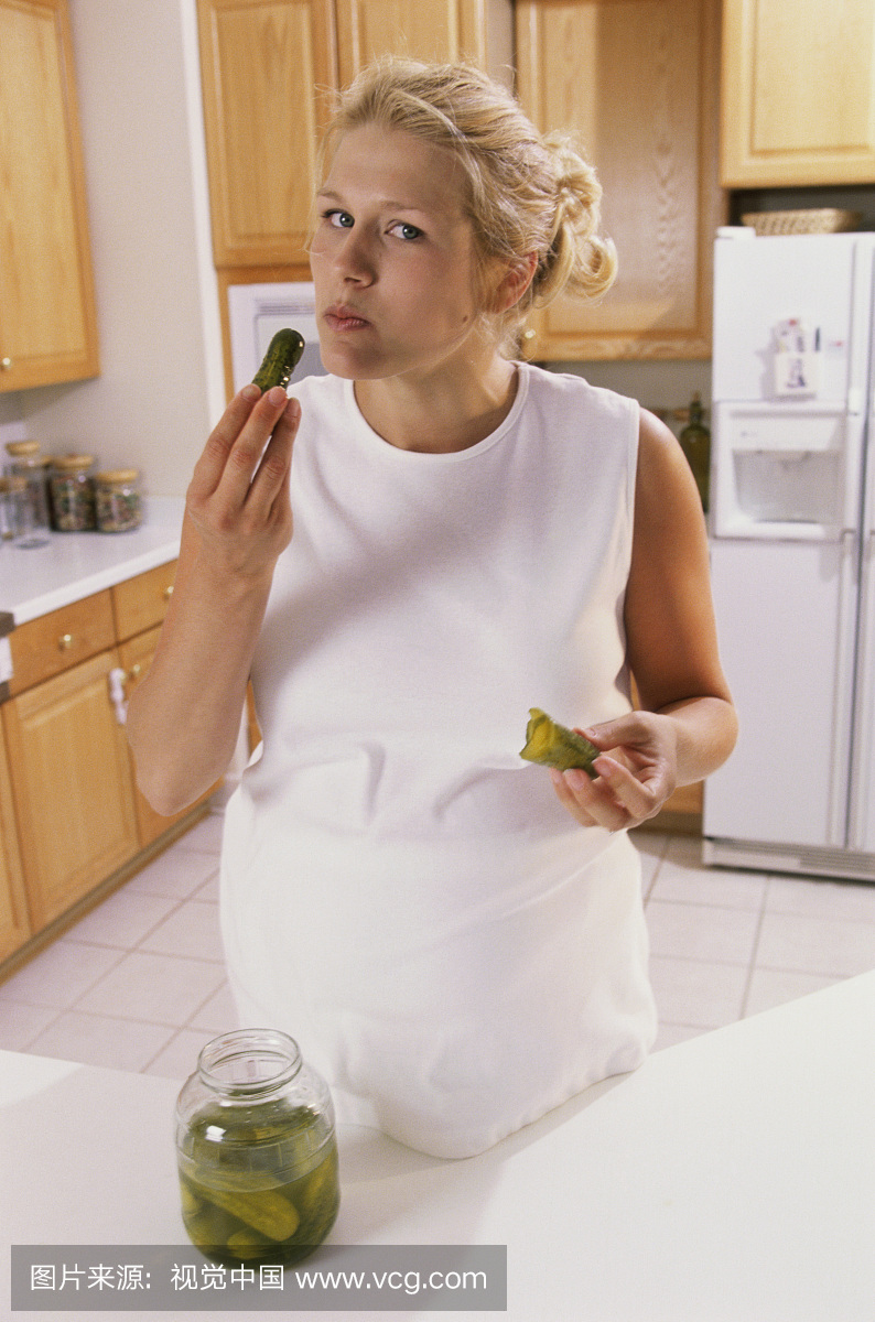 怀孕的女人吃泡菜的肖像