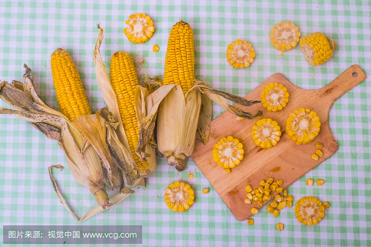 Sliced corn on the cob on chopping board, with