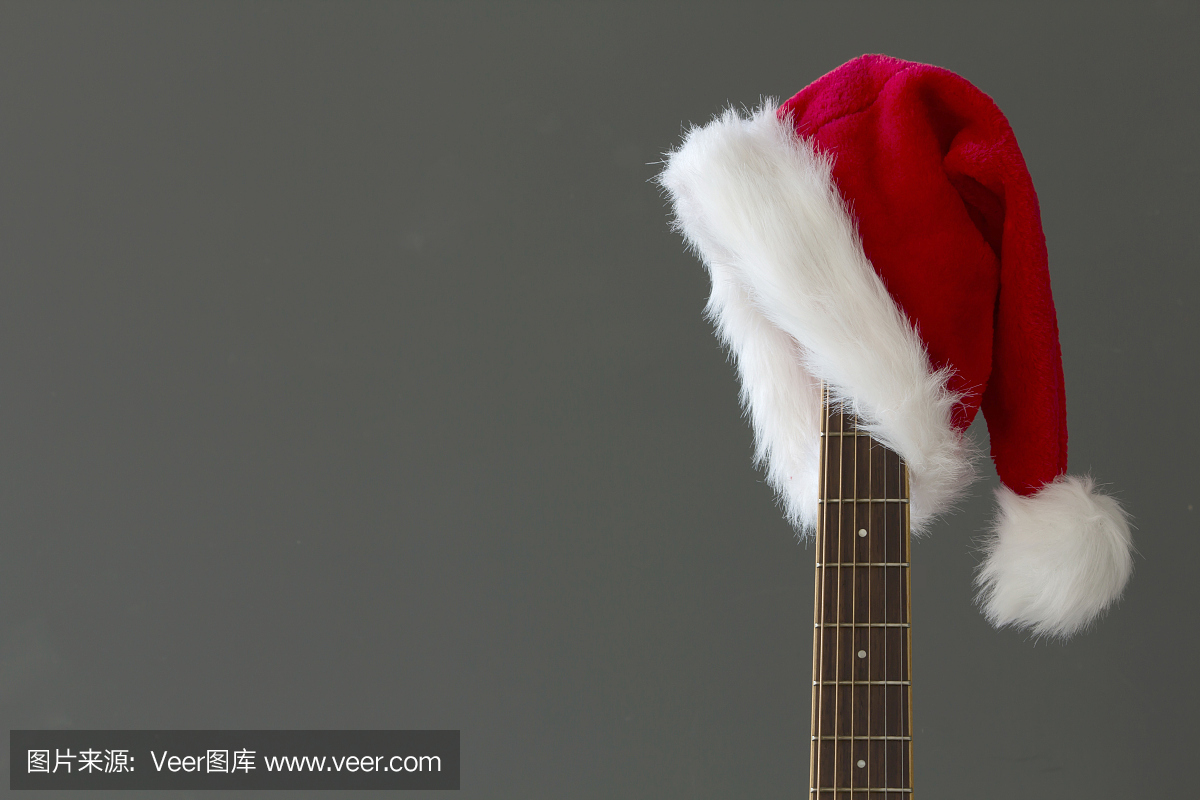 红色圣诞帽子吉他与灰色背景,圣诞快乐的歌曲