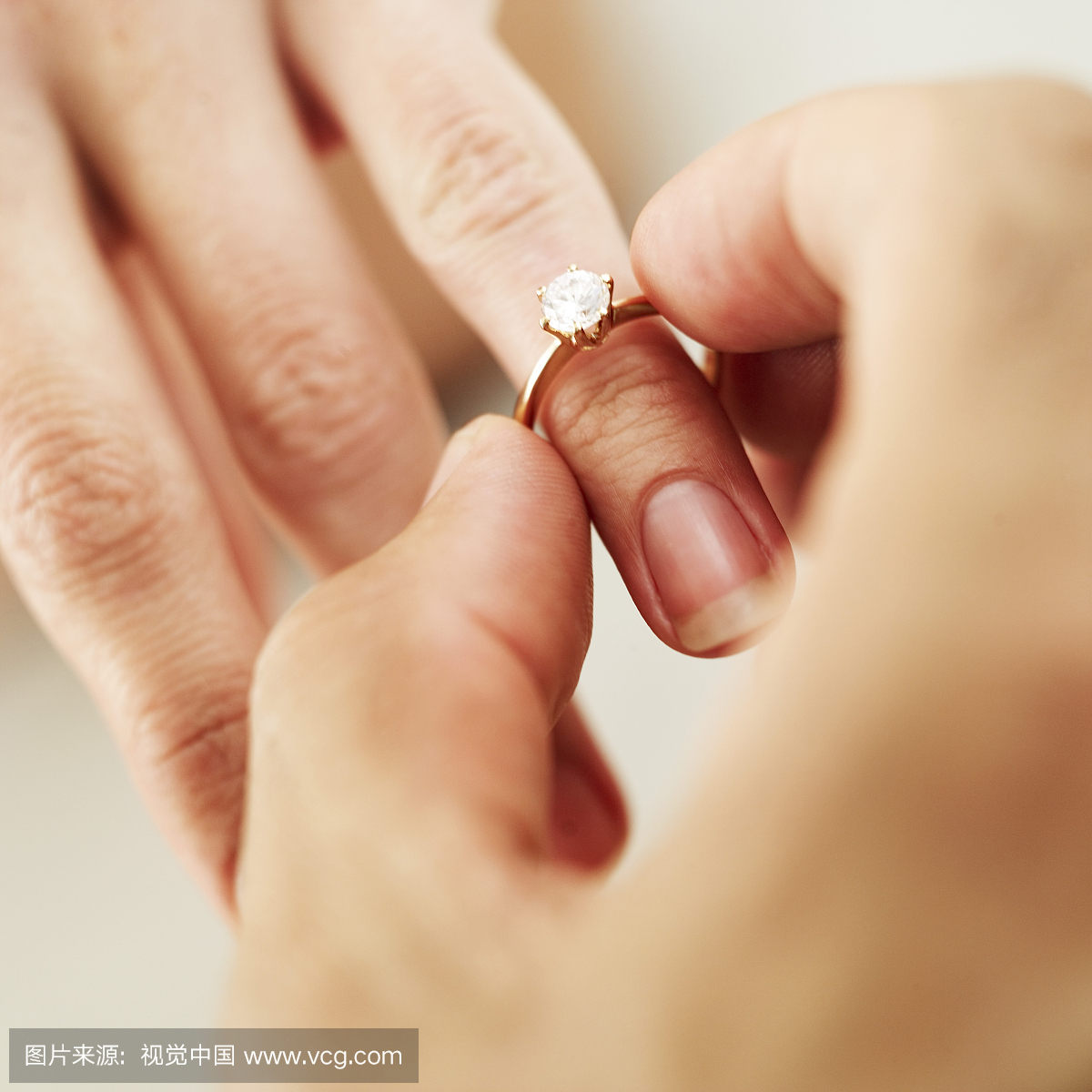 特写一个男人的手把一个钻石订婚戒指一个女人