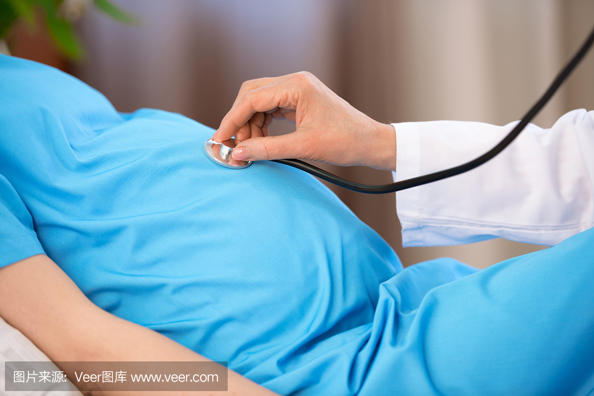 用听诊器拍摄的医生拍摄怀孕妇女躺在病床上的