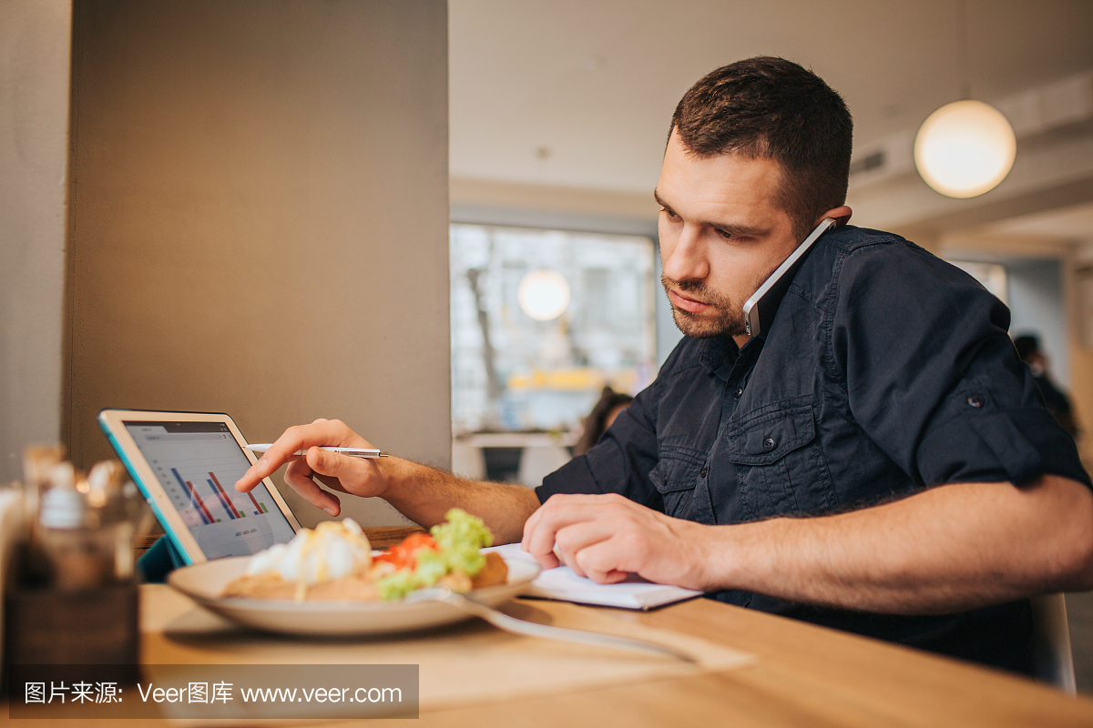 商人在咖啡厅用餐的图片。他现在正在工作。盖