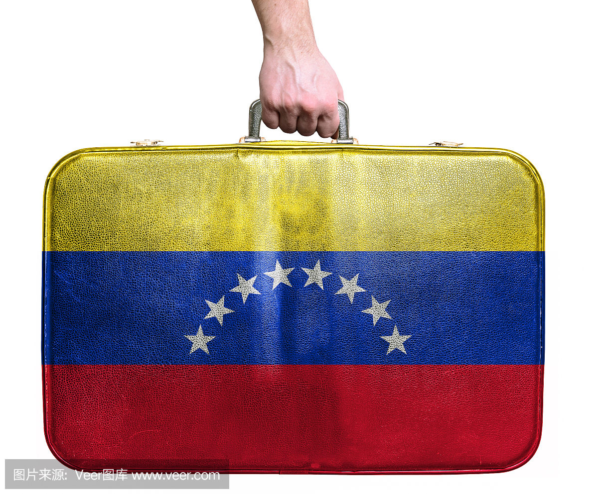 拿着委内瑞拉国旗的复古旅行袋的旅游手