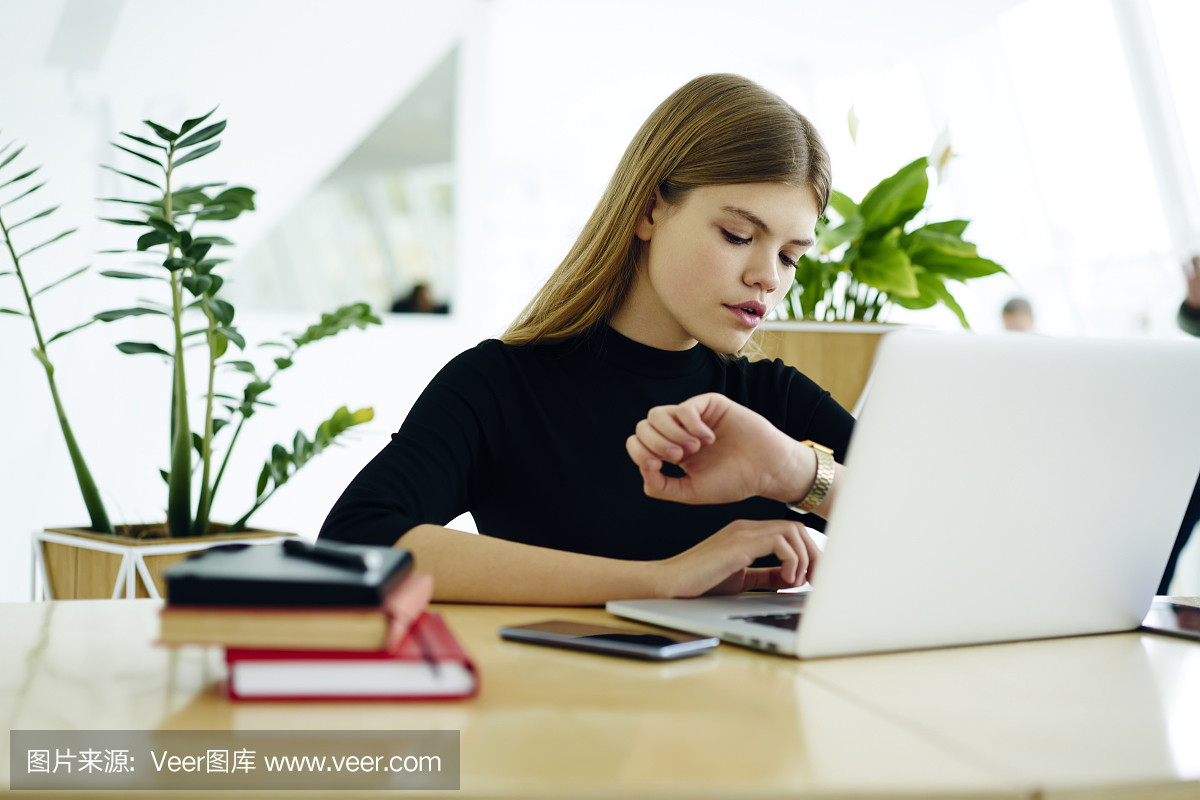 明的学生管理时间坐在笔记本电脑在准备考试期