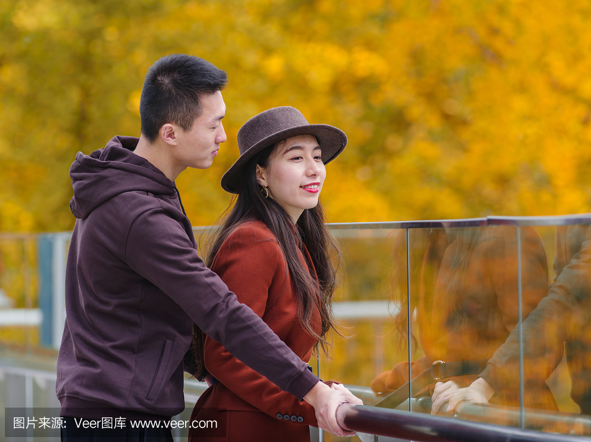 中国年轻的男人和女人手牵着手,站在一起与情
