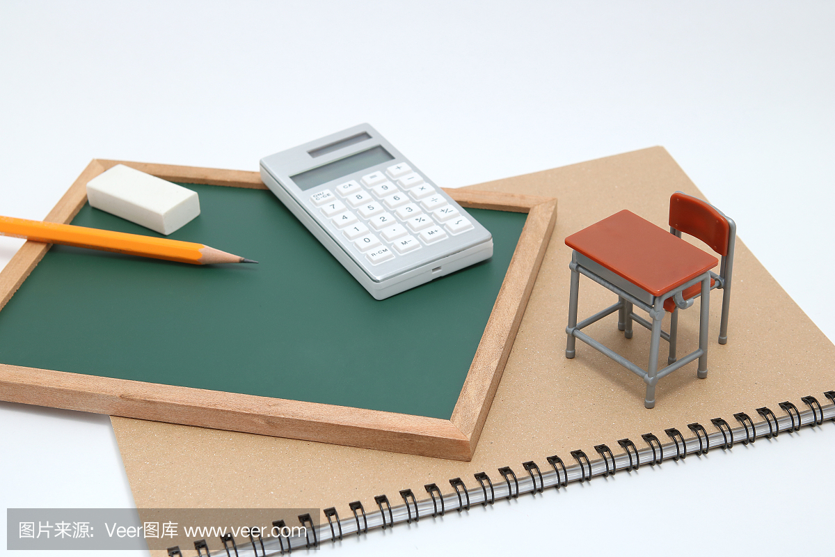 微型学校书桌,黑板和白色背景上的计算器。