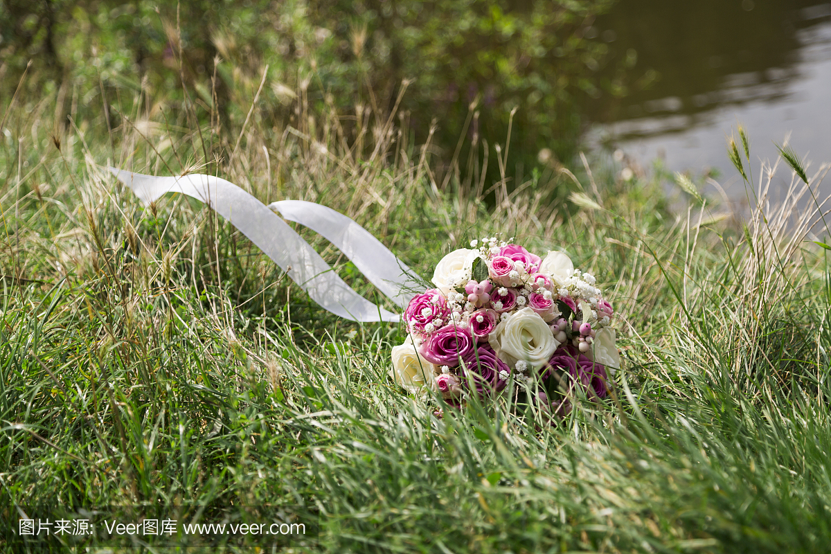 浪漫新鲜的婚礼花束在绿色草地上